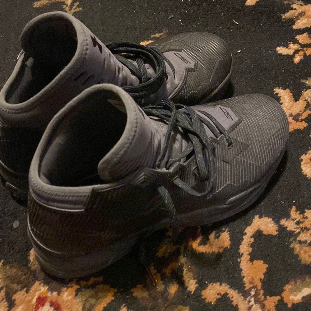 Curry shoes that are black in color with some grey around the tongue Size 9